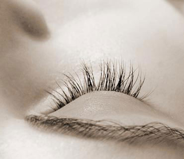 Close-up photo of a woman's eye that is closed in a deeply relaxed state.